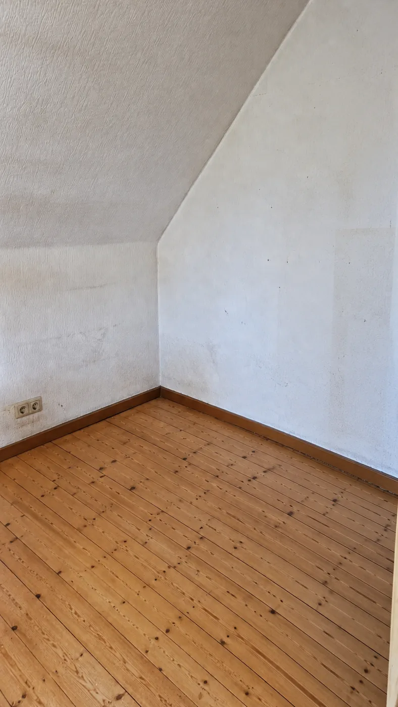 Leere Dachschräge mit Holzdielen nach der Räumung