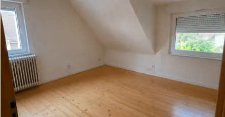 Leeres, besenreines Dachgeschoss-Zimmer mit Holzdielen nach der Haushaltsauflösung