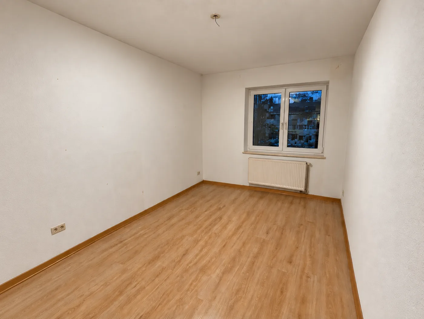 Leeres Zimmer mit Fenster und Heizkörper nach der Räumung
