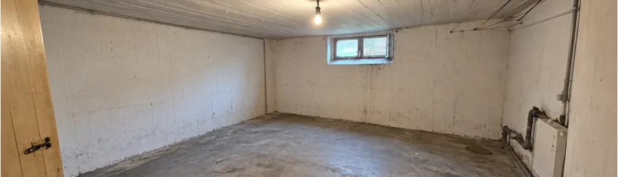 Leerer, besenreiner Kellerraum mit Fenster nach der Räumung