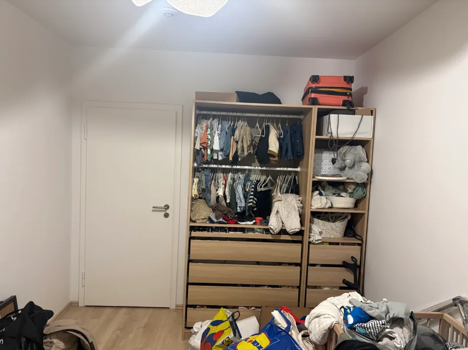 Kinderzimmer mit Schrank, Taschen und Kleidung vor der Räumung